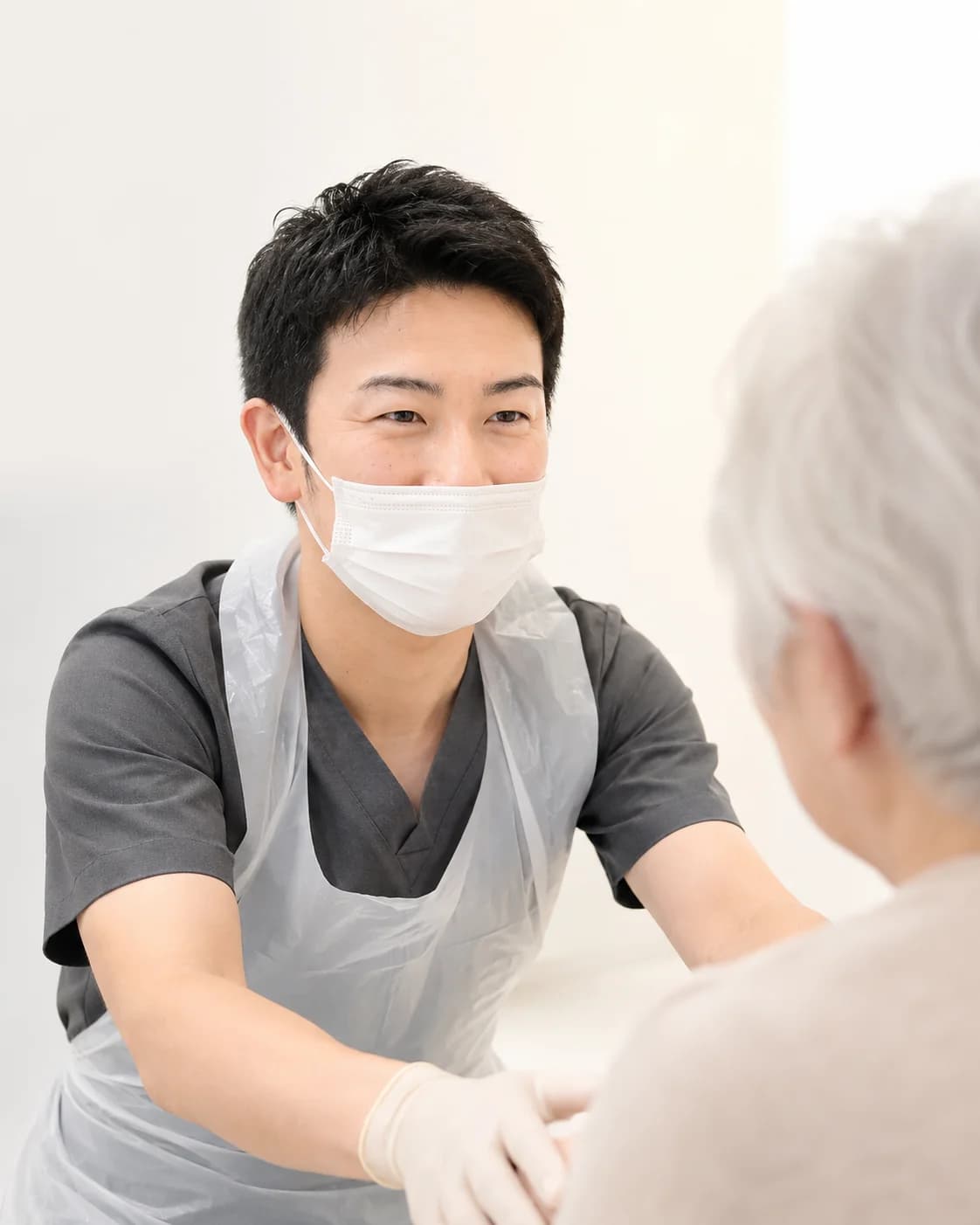 高齢の患者に向き合う歯科医師