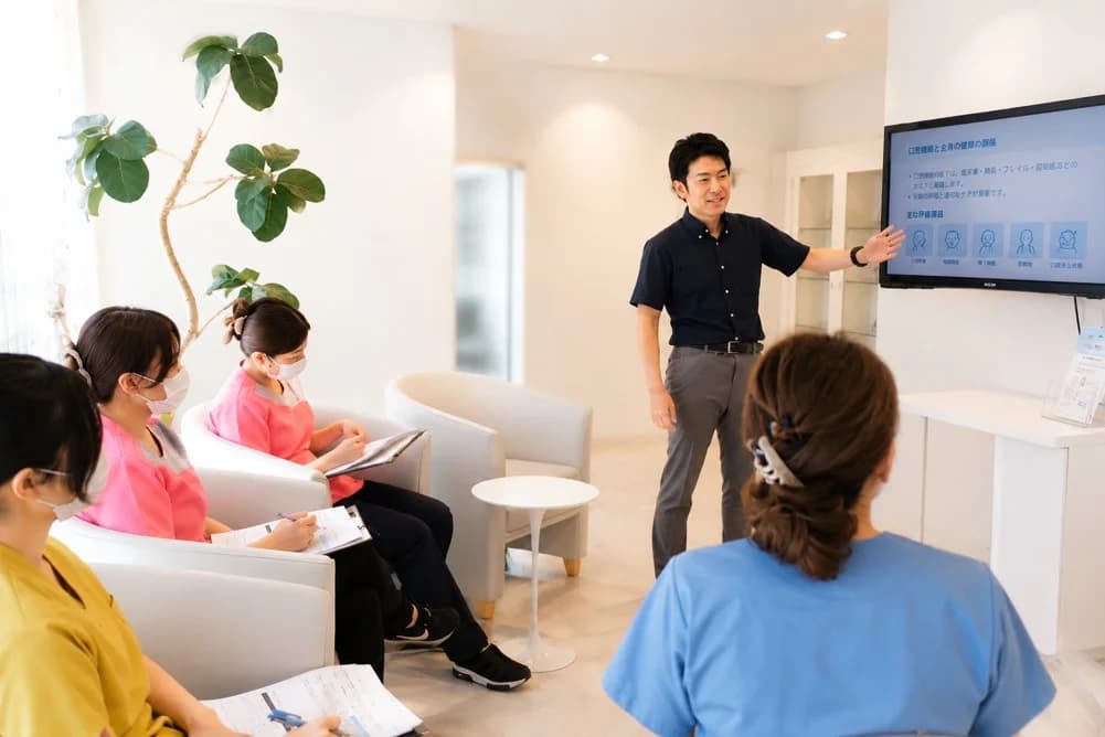 歯科医院のスタッフに向けて口腔機能について講演する歯科医師